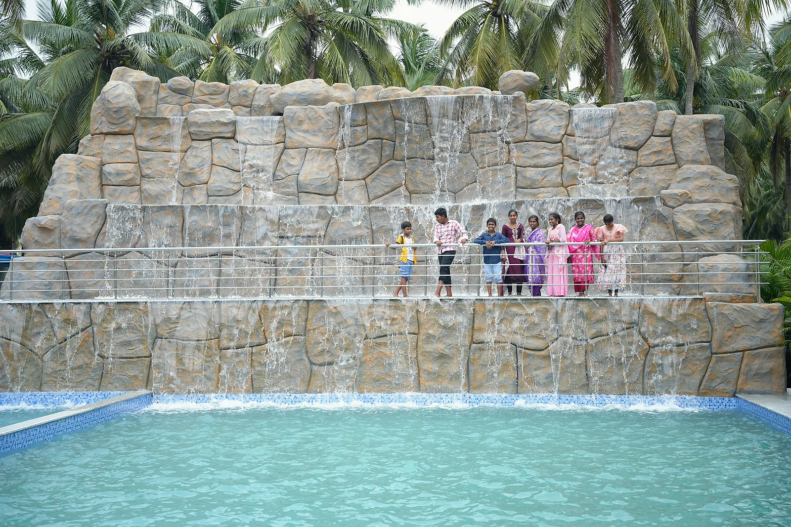 Guests posing on the bridge in front of the resort's cascading waterfall