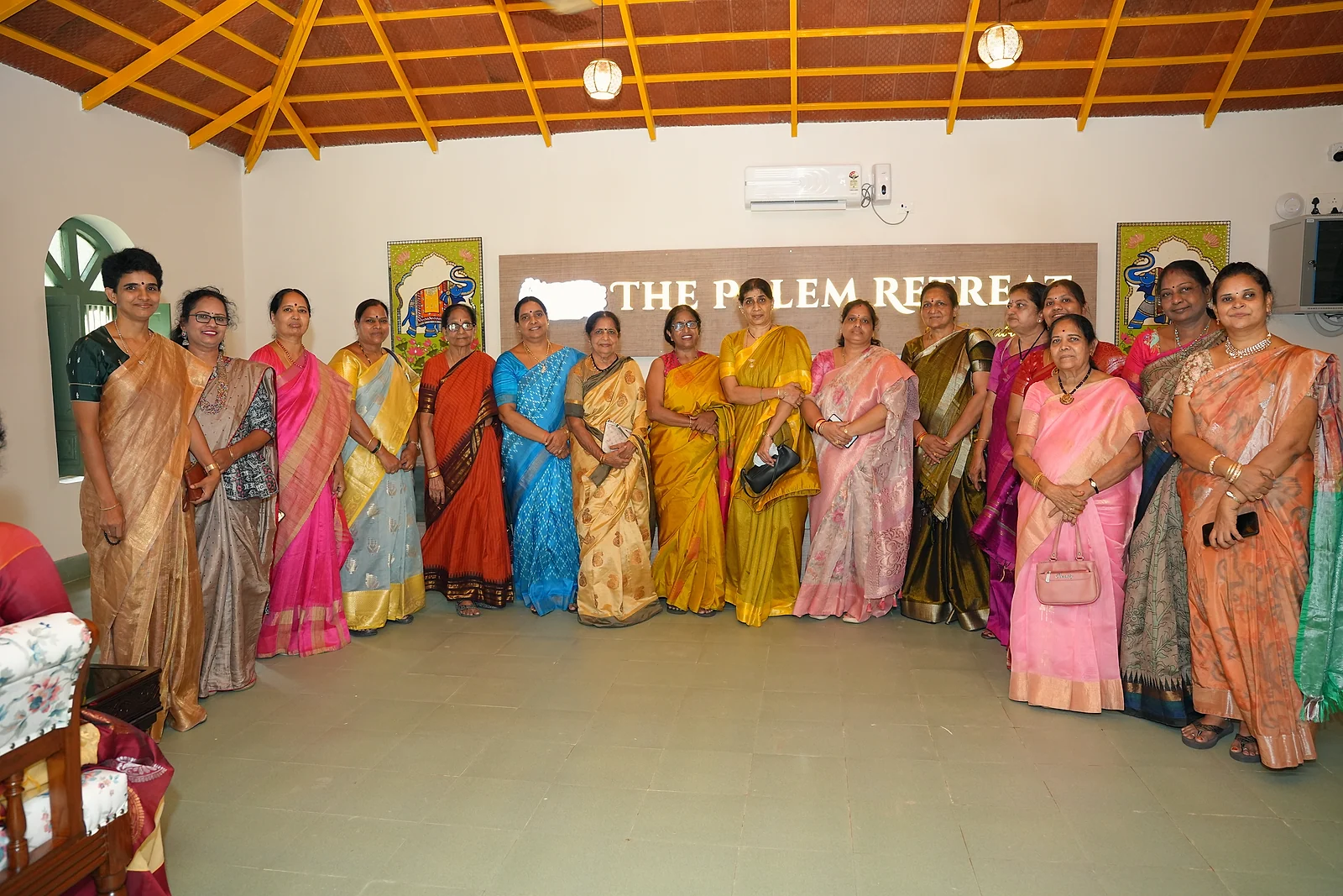 A group of guests in colourful sarees inside the resort reception