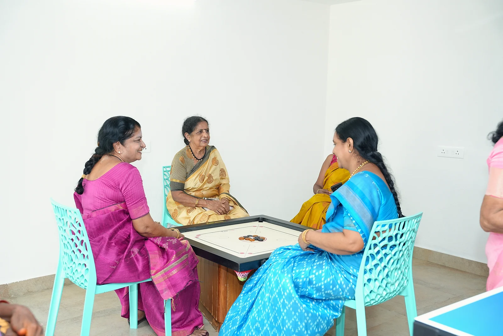 Guests enjoying a board game around a table in the recreation room