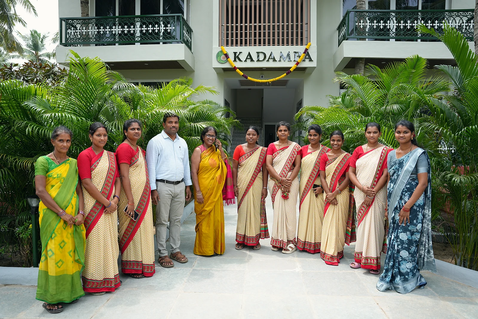 A group of guests posing in front of the Kadamba building and landscaped gardens