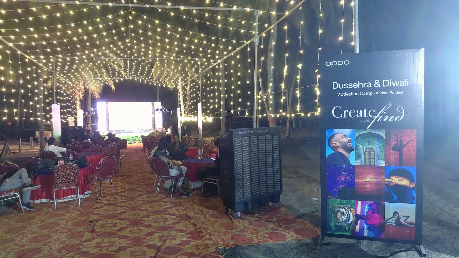 Guests seated beneath string lights beside an OPPO event banner