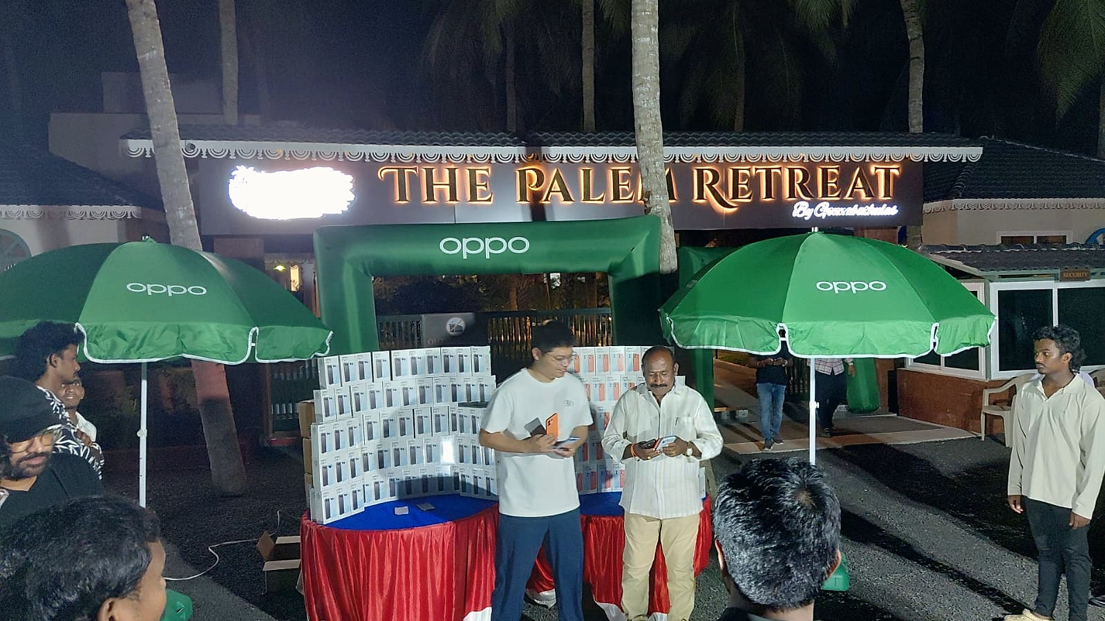 Attendees gathered around the OPPO phone display outside The Palem Retreat